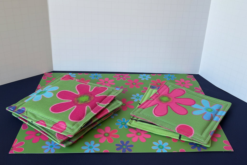 Floral coasters with a glass drink container on a matching mat.